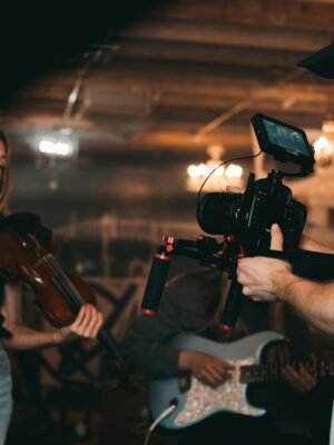 Man Taking a Video of a Woman Carrying a Violin