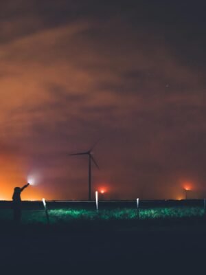 Photography of Person Holding Flashlight Near Windmills during Night Time